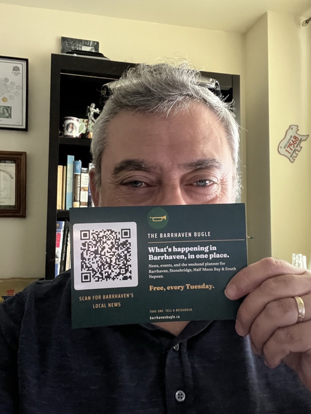 Jay Tarzwell holding one of the 250 Barrhaven Bugle postcards he handed out door to door.